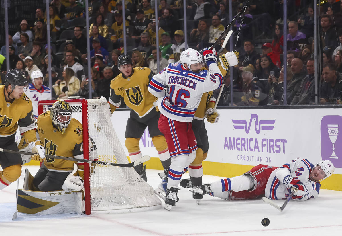 New York Rangers left wing Alexis Lafreniere (13) poke checks the puck from the ice against the ...
