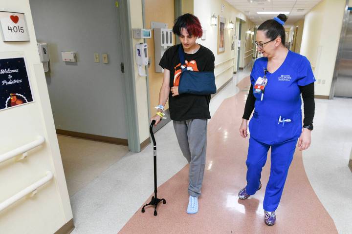 Mason Huff is assisted by nurse Vida Mia Golembeski at he walks down the hallway at Sunrise Hos ...