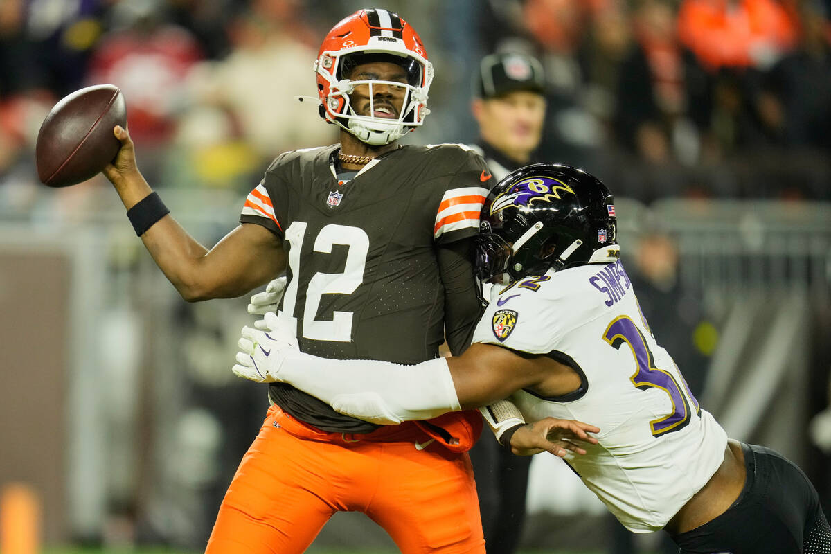 Cleveland Browns quarterback Shedeur Sanders (12) passes as he is hit by Baltimore Ravens lineb ...