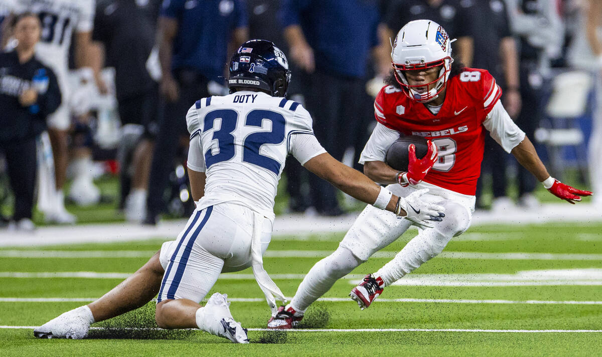 UNLV wide receiver Taeshaun Lyons (8) cuts hard to fake out a tackle attempt by Utah State Aggi ...