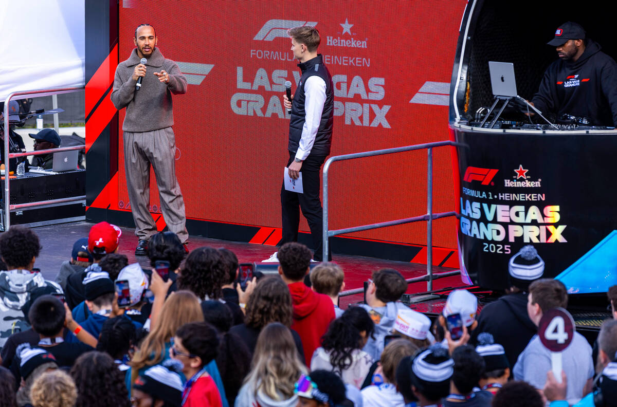 Formula One driver Lewis Hamilton answers questions before a group of students during community ...