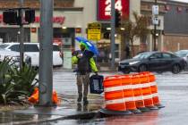 A person with an umbrella walks along Paradise Road as moderate to heavy rain moves through the ...