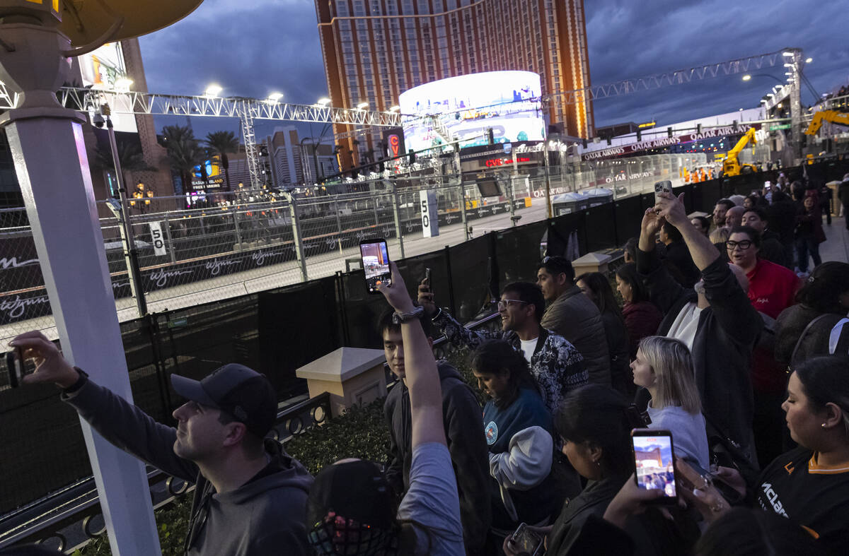 People watch and record the first practice of the Formula One Las Vegas Grand Prix auto race al ...
