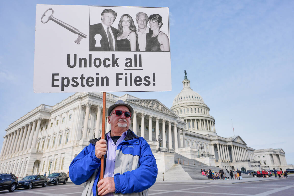 Gary Rush, College Park, MD, holds a sign before a news conference on the Epstein files in fron ...