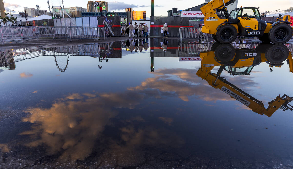 A group from the Girl Scouts of Southern Nevada are reflected in large rain puddle about the F1 ...