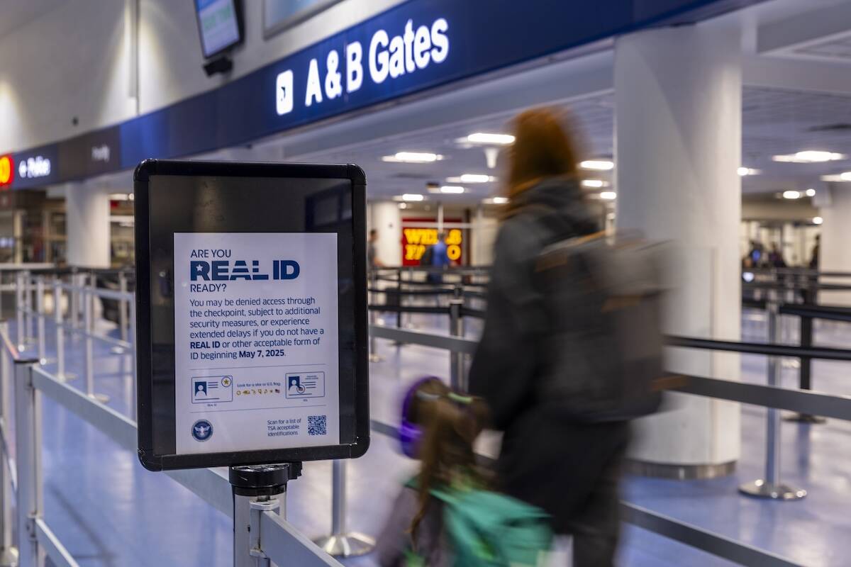 Travelers make their way to a TSA security checkpoint in Terminal One as the Real ID act is bei ...