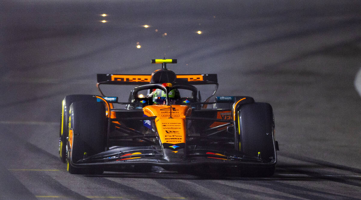 McLaren driver Lando Norris (4) sends up a few sparks as he navigates the final turn during the ...