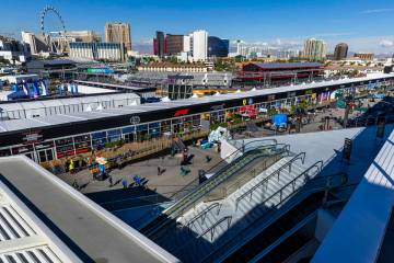 People walk about the team hospitality area with the track and skyline beyond during a tour of ...