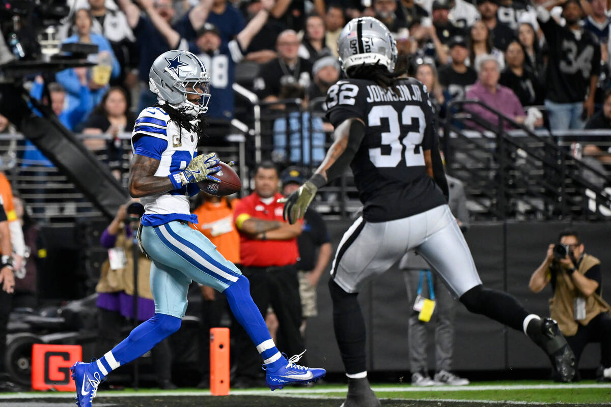 Dallas Cowboys wide receiver CeeDee Lamb, left, makes a touchdown catch as Las Vegas Raiders sa ...