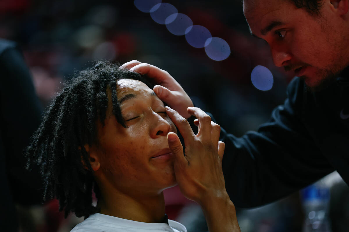 UNLV forward Tyrin Jones (6) has his eye examined after he was knocked down during the first ha ...