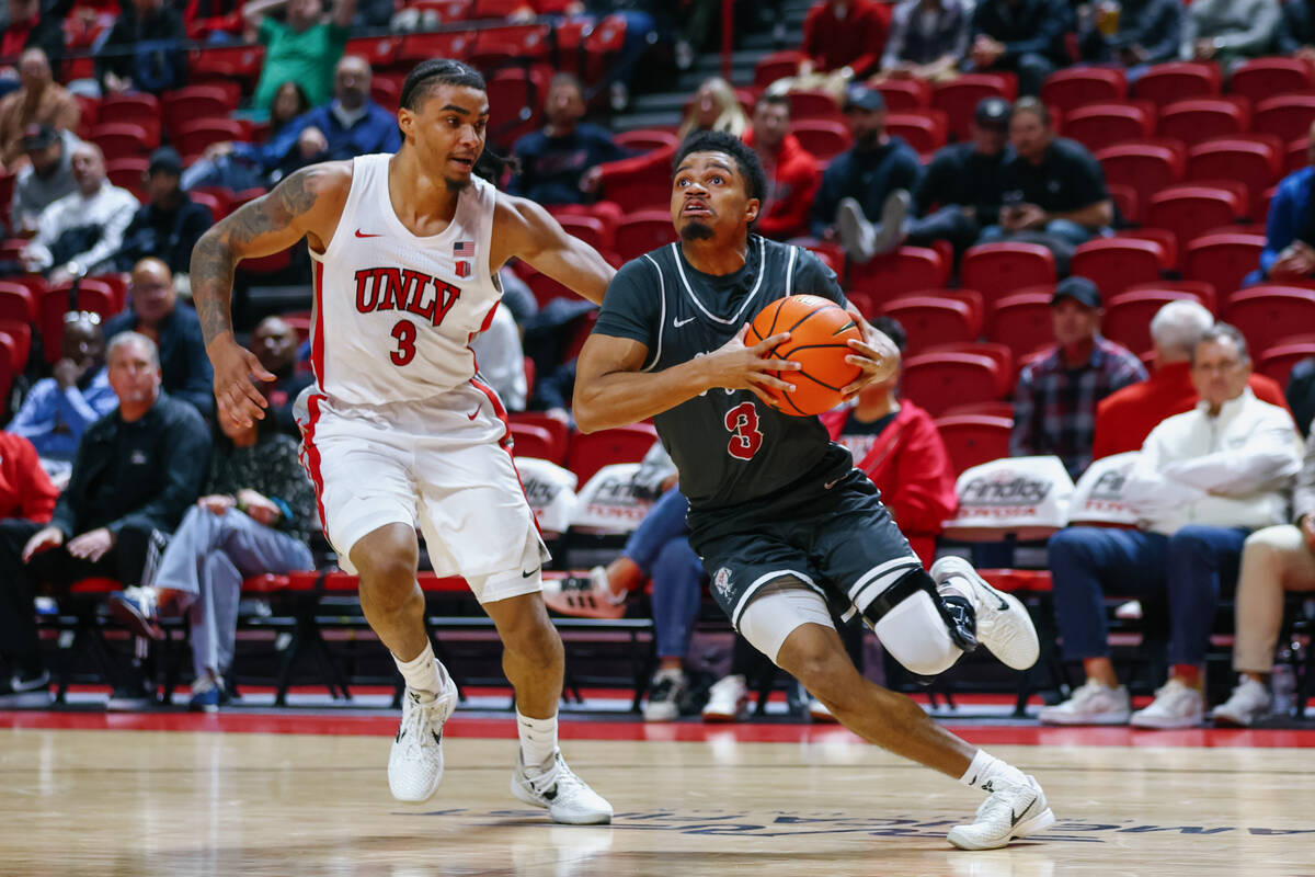 St. Joseph guard Khaafiq Myers (3) drives toward the net as UNLV guard Howie Fleming Jr. (3) pu ...