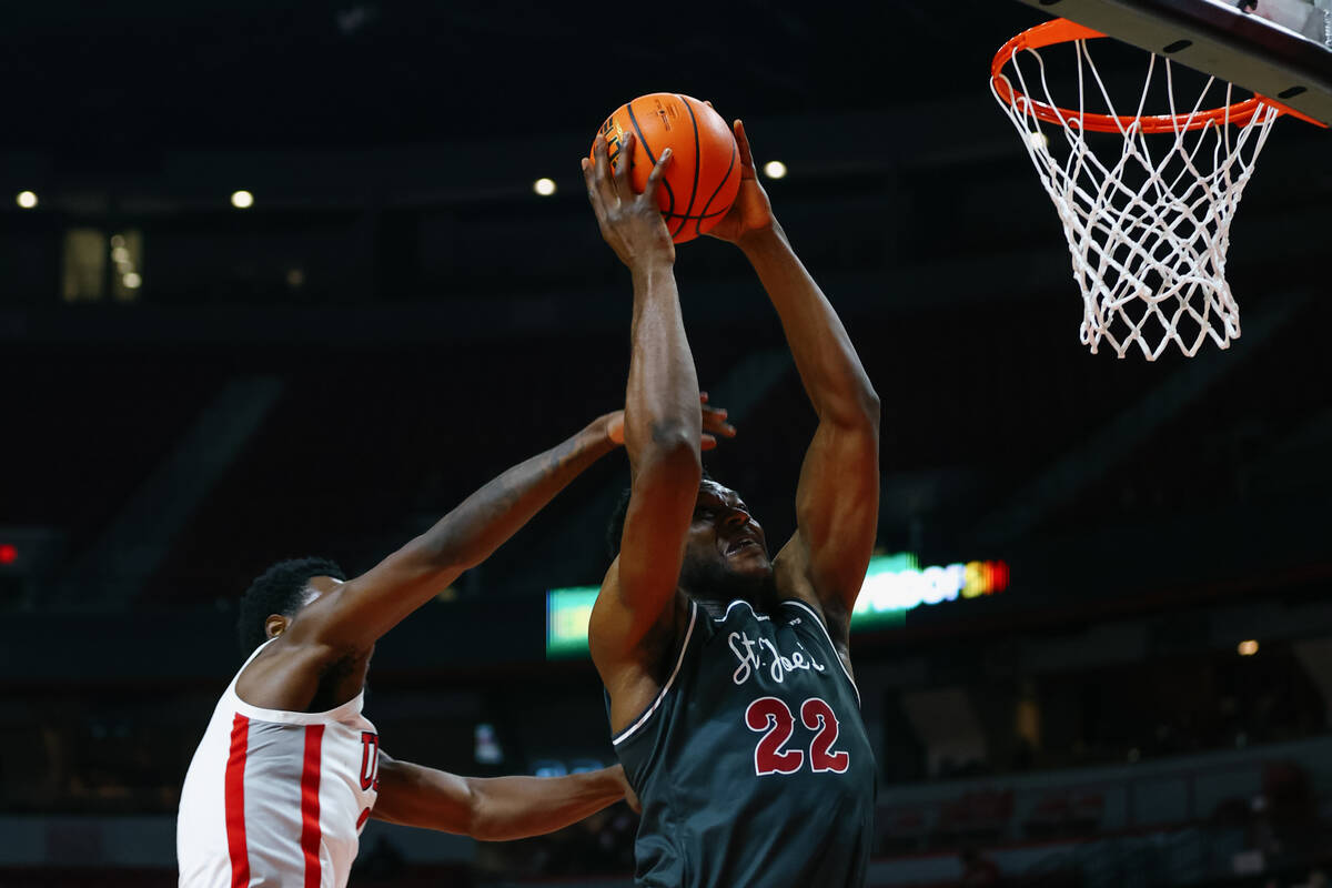 St. Joseph center Justice Ajogbor (22) takes a shot as UNLV forward Kimani Hamilton (2) tries t ...