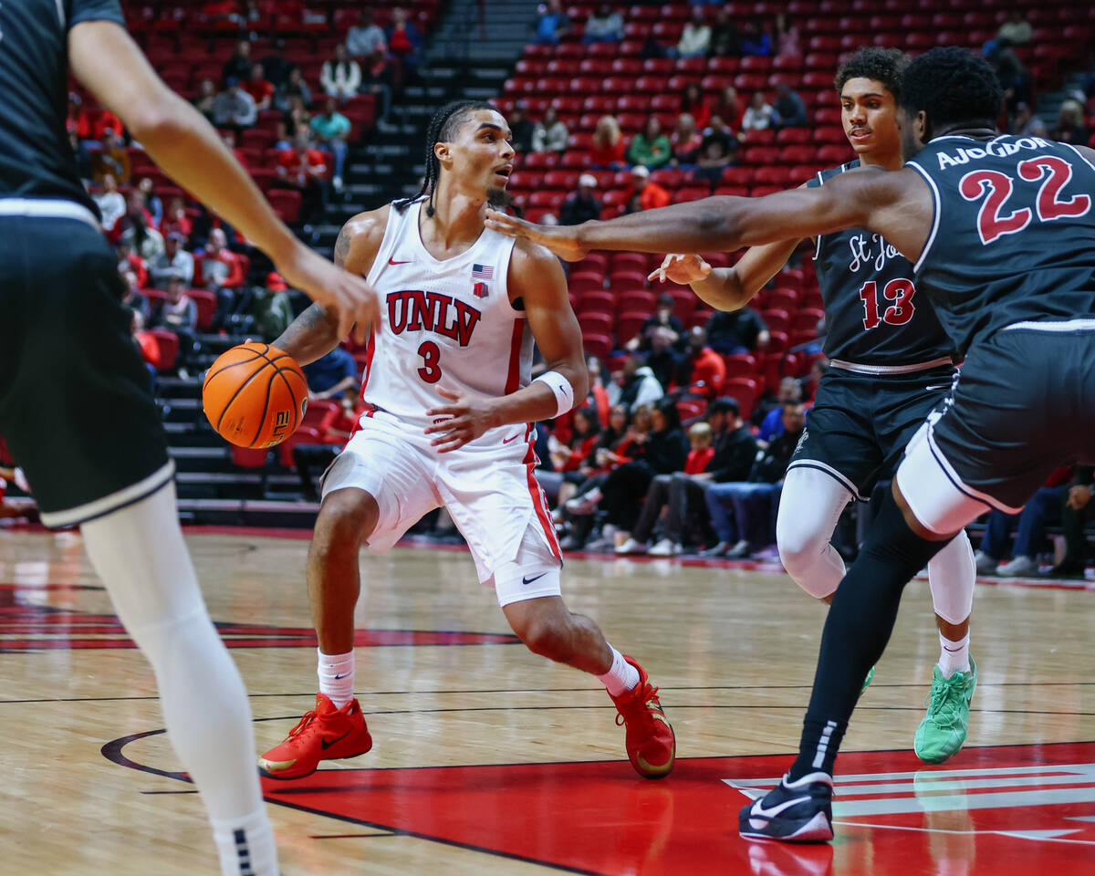 UNLV guard Howie Fleming Jr. (3) looks for an opening around several St. Joseph players during ...