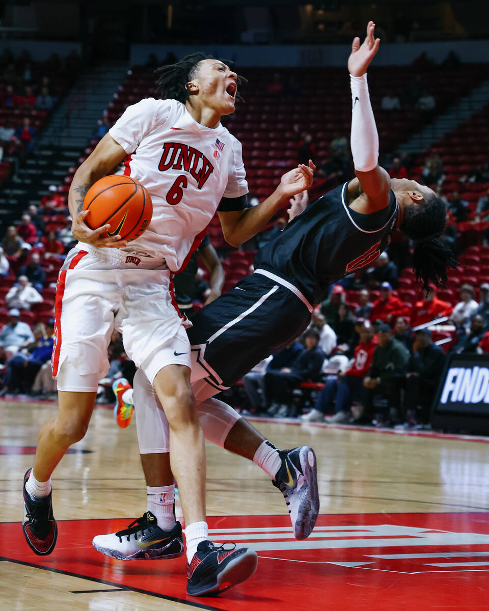 UNLV forward Tyrin Jones (6) collides with St. Joseph guard Jaiden Glover-Toscano (11) on his w ...