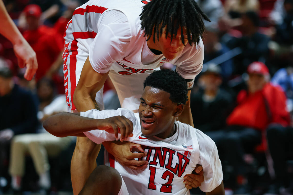 UNLV forward Tyrin Jones (6) helps UNLV guard Issac Williamson (12) off the ground after Willia ...