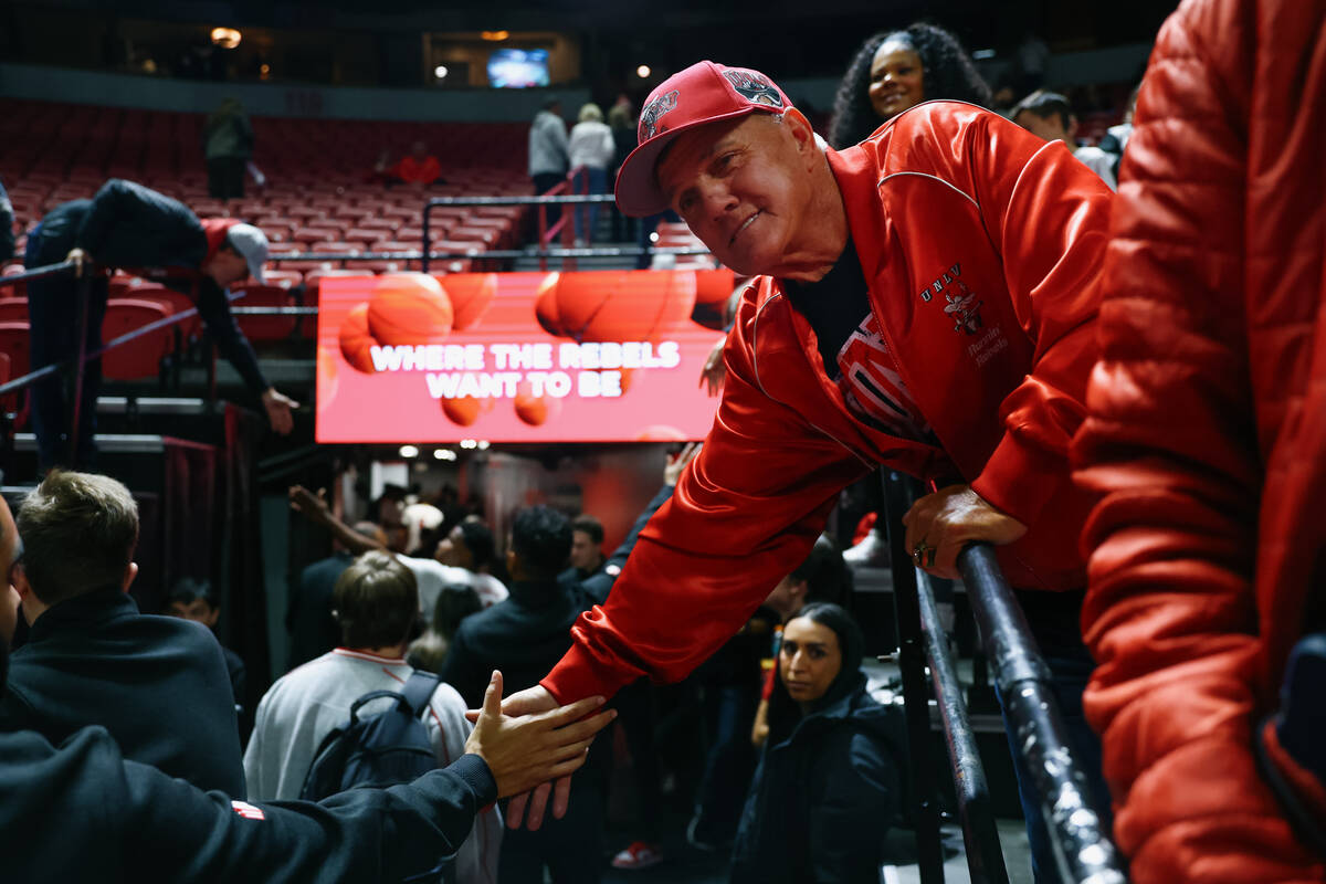 UNLV fan Mike Mount claps hands with the UNLV coaching staff after the Rebels’ win over ...