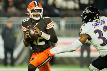 Cleveland Browns quarterback Shedeur Sanders (12) is pursued by Baltimore Ravens linebacker Tre ...