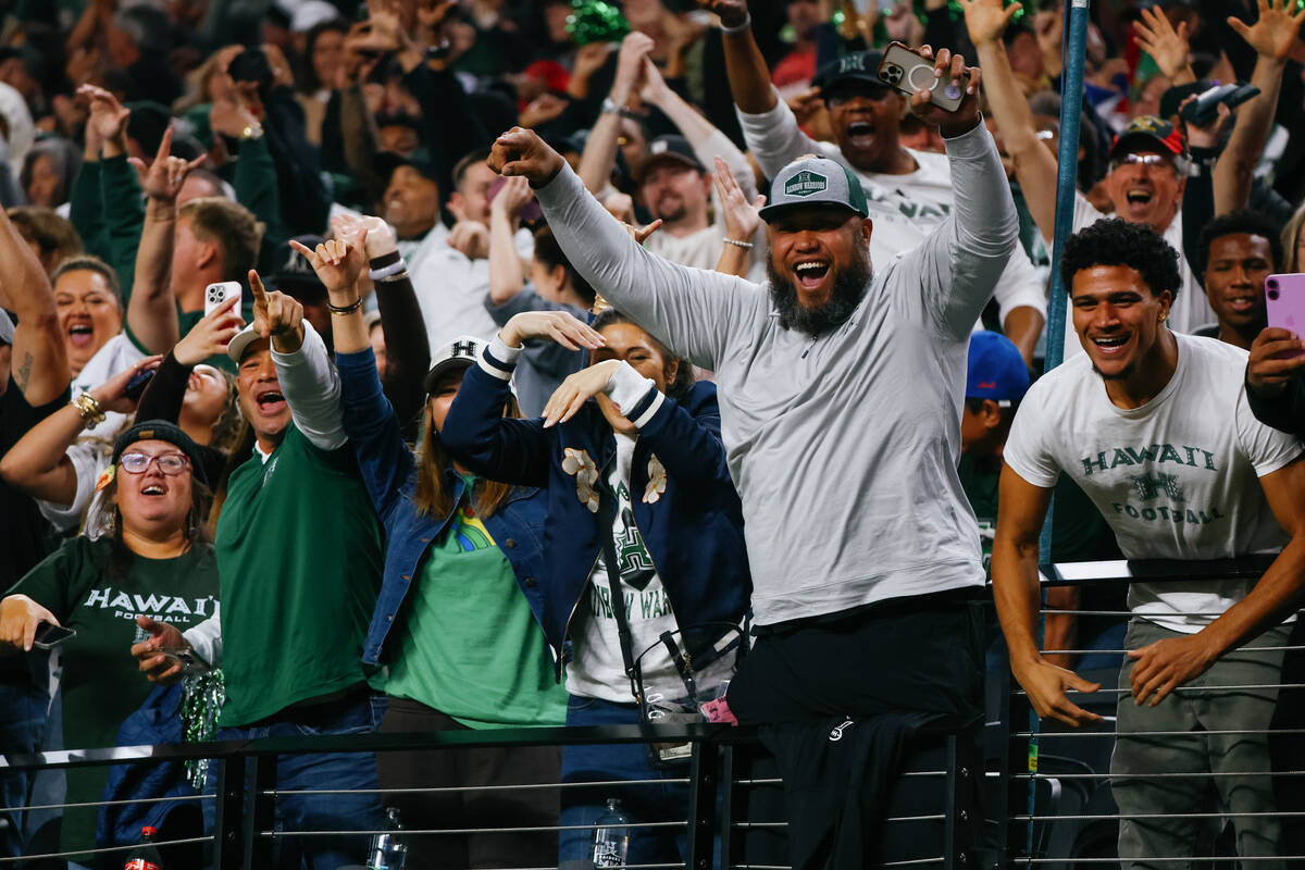 Hawaii fans celebrate a run-in touchdown for their team during the first half of the Ninth Isla ...