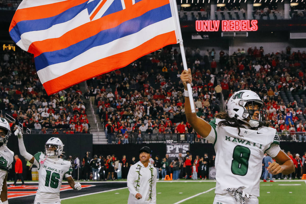 Hawaii defensive back Kilinahe Mendiola-Jensen (8) runs out with the flag before the first half ...