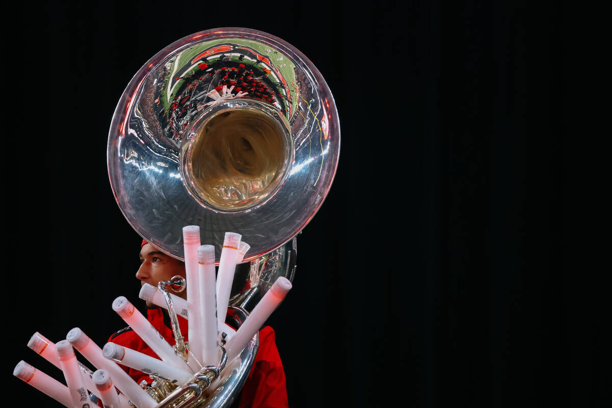 A UNLV marching band member stands with his sousaphone full of light sticks during the second h ...