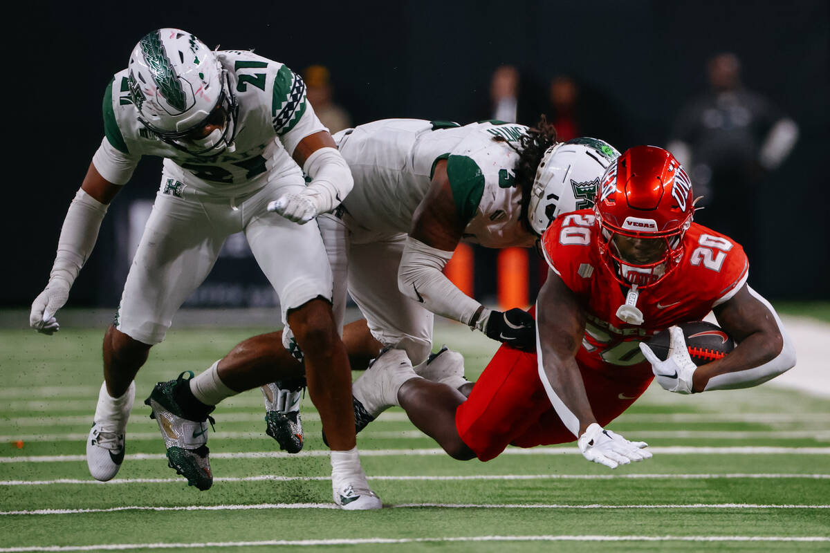 Hawaii linebacker Jalen Smith (3) and Hawaii defensive back Justin Sinclair (21) tackle UNLV ru ...