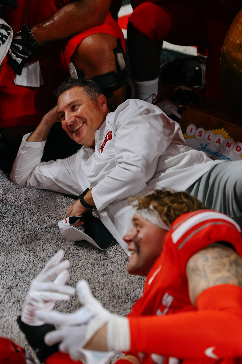 UNLV head coach Dan Mullen poses for a group photo with the team and the golden pineapple troph ...