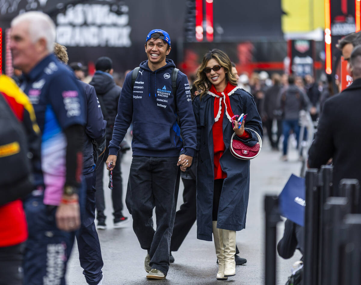 Williams driver Alex Albon (23) arrives with his girlfriend Lily Muni He before practice 3 at t ...