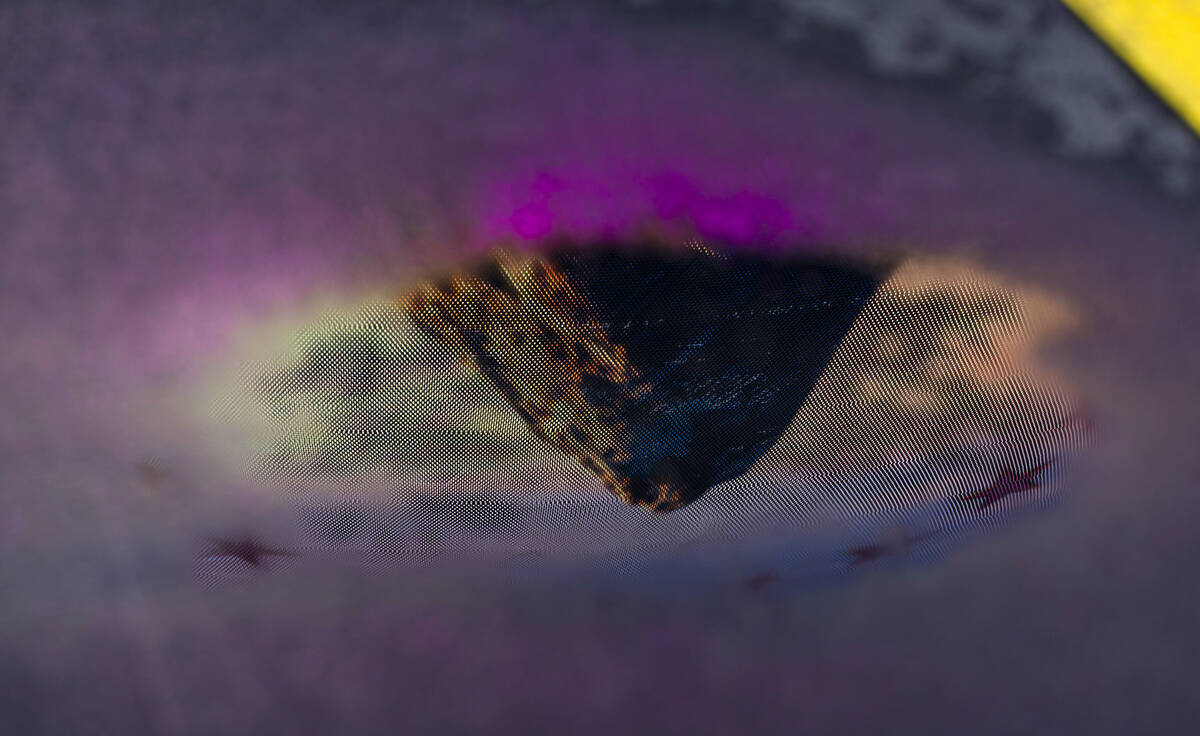The Prudential mountain peak is reflected in a puddle about the Sphere before the start of prac ...