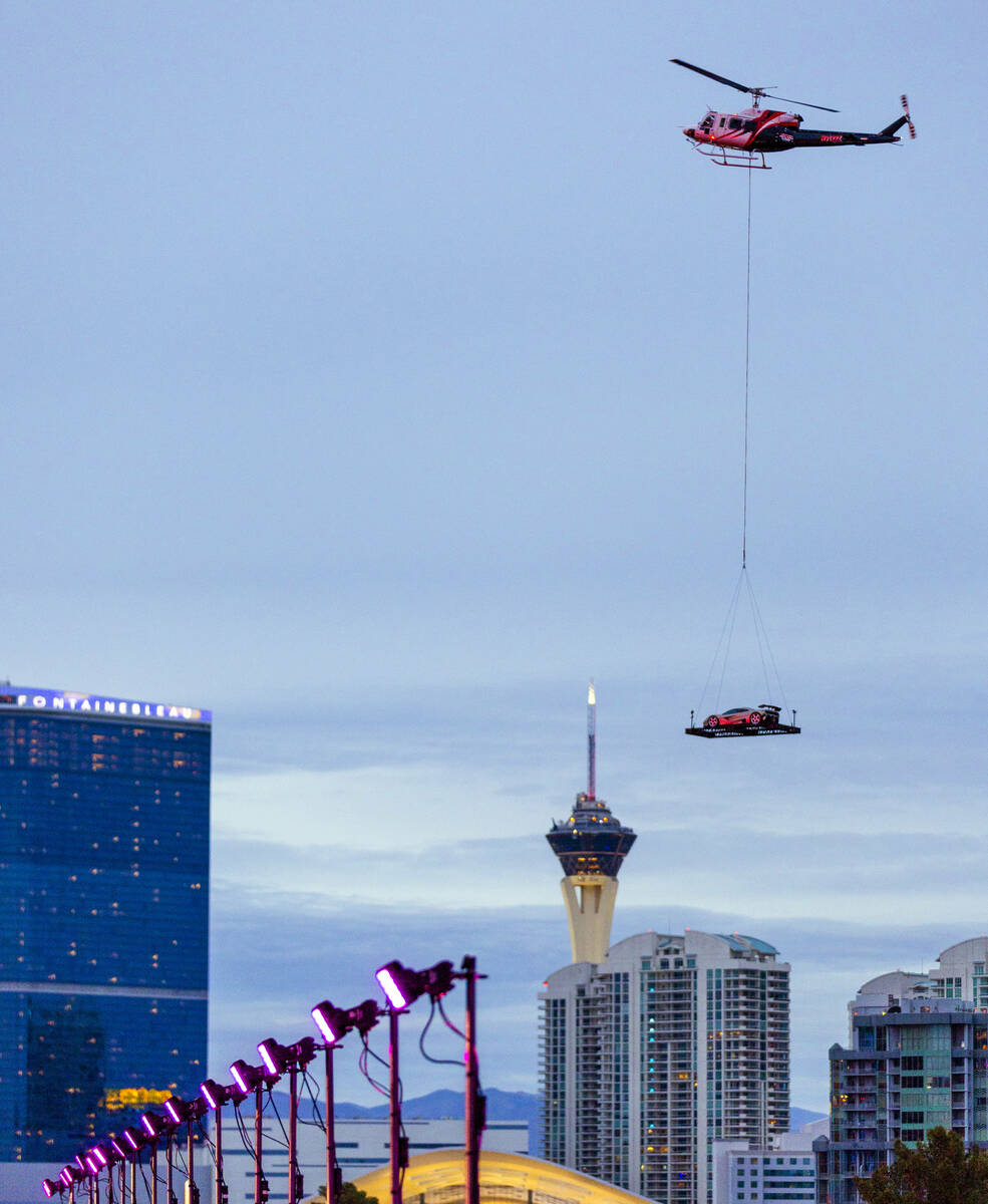 A helicopter carries a race car on a flat near the Sphere before the start of practice 3 at the ...