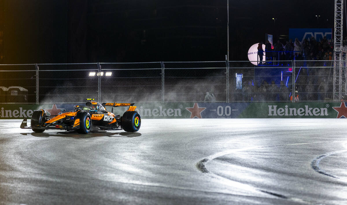 McLaren driver Lando Norris navigates turn 1 in the rain during the qualifying race at the Las ...
