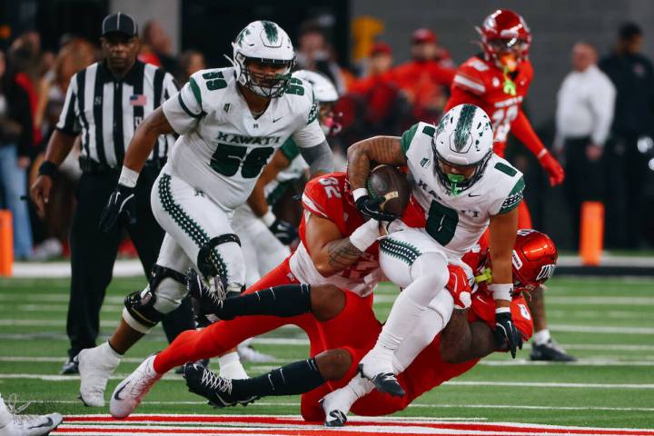 UNLV defensive end Kenji Scanlan (32) and UNLV linebacker Marsel McDuffie (8) take down Hawaii ...