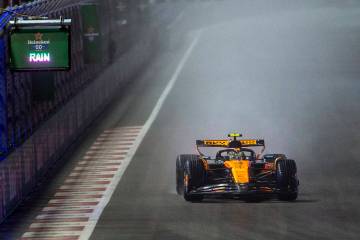 McLaren driver Lando Norris approaches turn 1 in the rain during the qualifying race at the Las ...