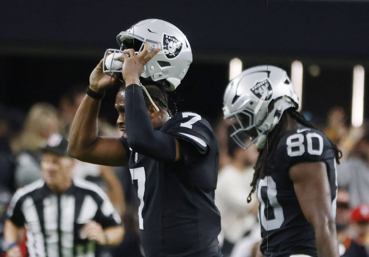 Raiders quarterback Geno Smith (7) takes off his helmet in frustration as he leaves the field d ...