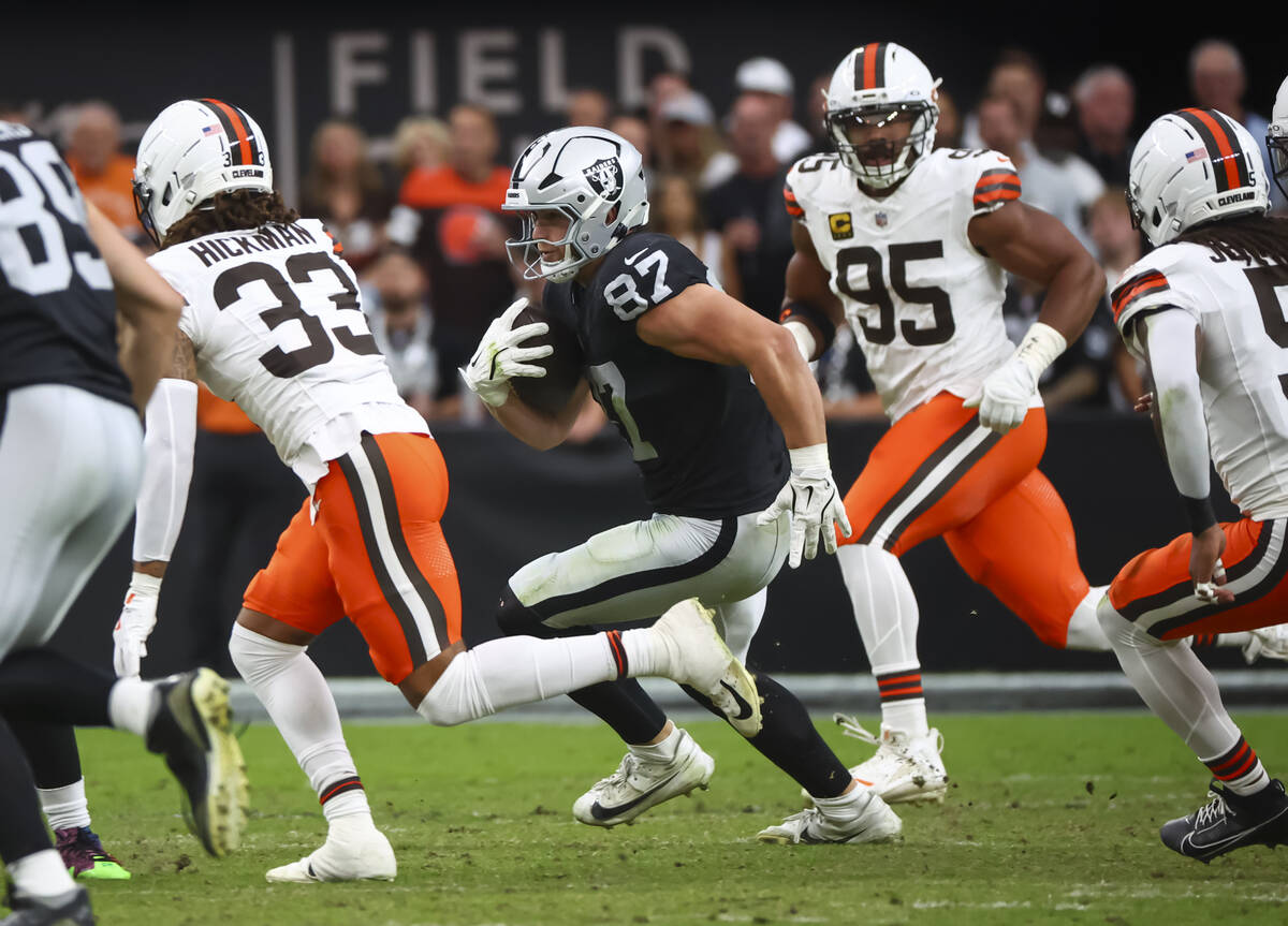 Raiders tight end Michael Mayer (87) runs the ball under pressure from Cleveland Browns safety ...