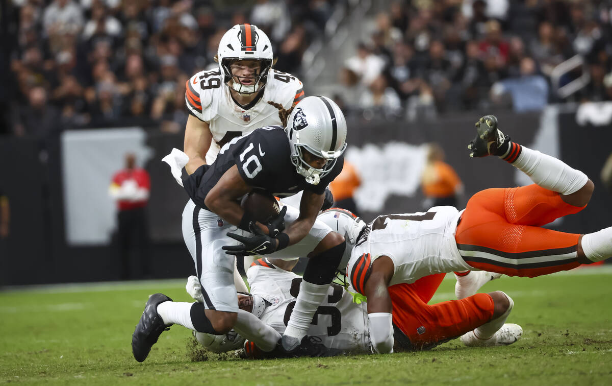 Raiders wide receiver Dont'E Thornton Jr. (10) gets tackled by Cleveland Browns safety Ron ...
