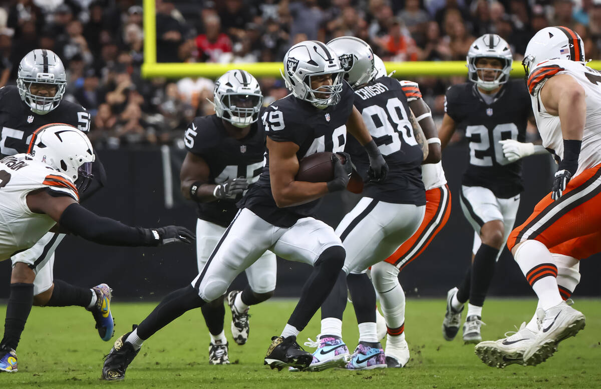 Raiders defensive end Charles Snowden (49) runs the ball after an interception against the Clev ...