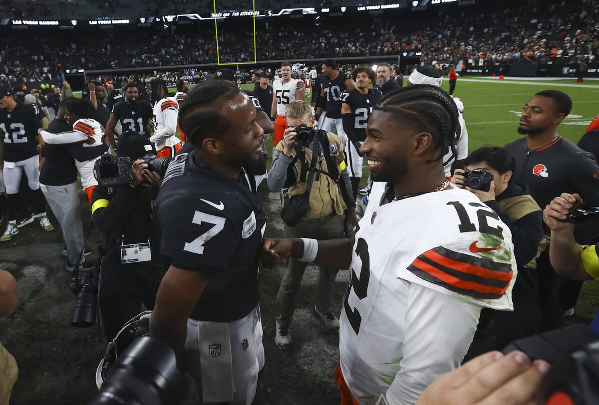 Raiders quarterback Geno Smith (7) talks with Cleveland Browns quarterback Shedeur Sanders (12) ...