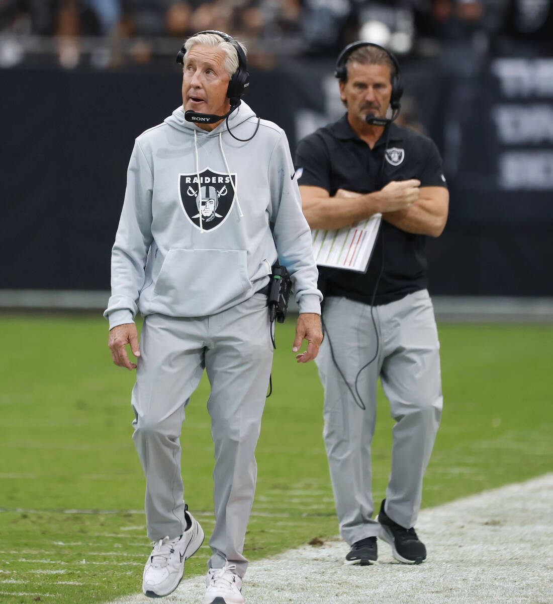 Raiders head coach Pete Carroll, left, and quarterbacks coach Greg Olson walk on the sideline d ...