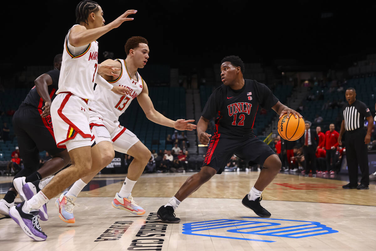 UNLV guard Issac Williamson (12) looks to pass the ball under pressure from Maryland Terrapins ...