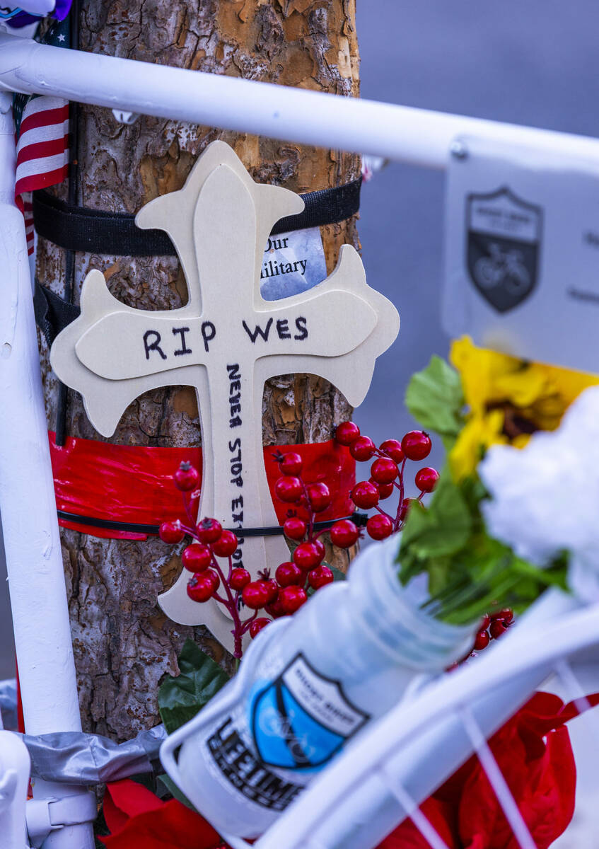 A cross for Wesley Ervin Sterner is attached a tree near the bike placed by Ghost Bikes Las Veg ...