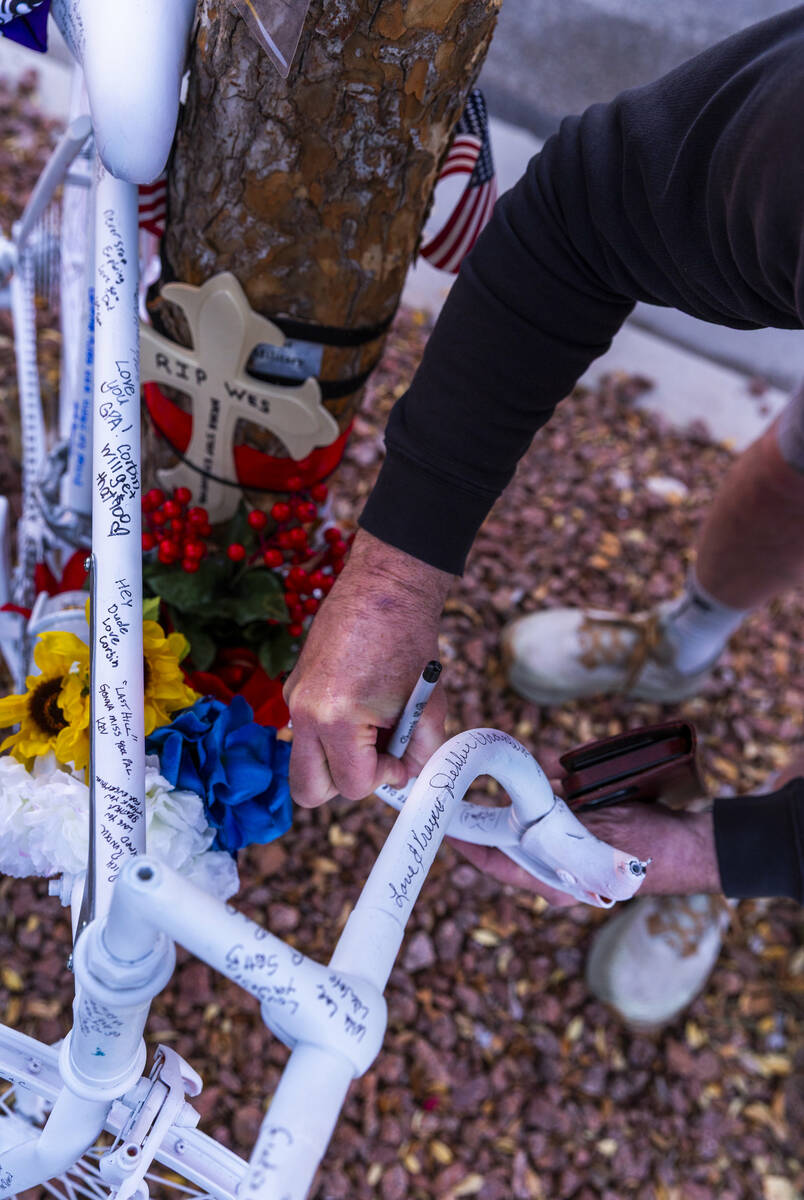 Attendees take a moment to sign a bike in honor of Wesley Ervin Sterner during a Ghost Bikes ce ...