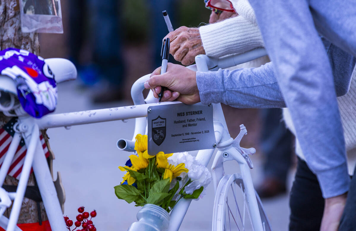 Attendees take a moment to sign a bike in honor of Wesley Ervin Sterner during a Ghost Bikes ce ...