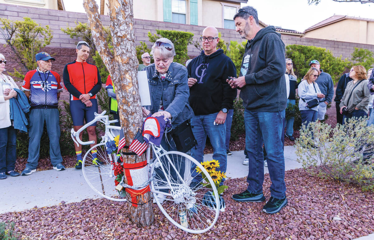 Linda Sterner and her son Shane, center, sign the bike dedicated to her husband and his father, ...