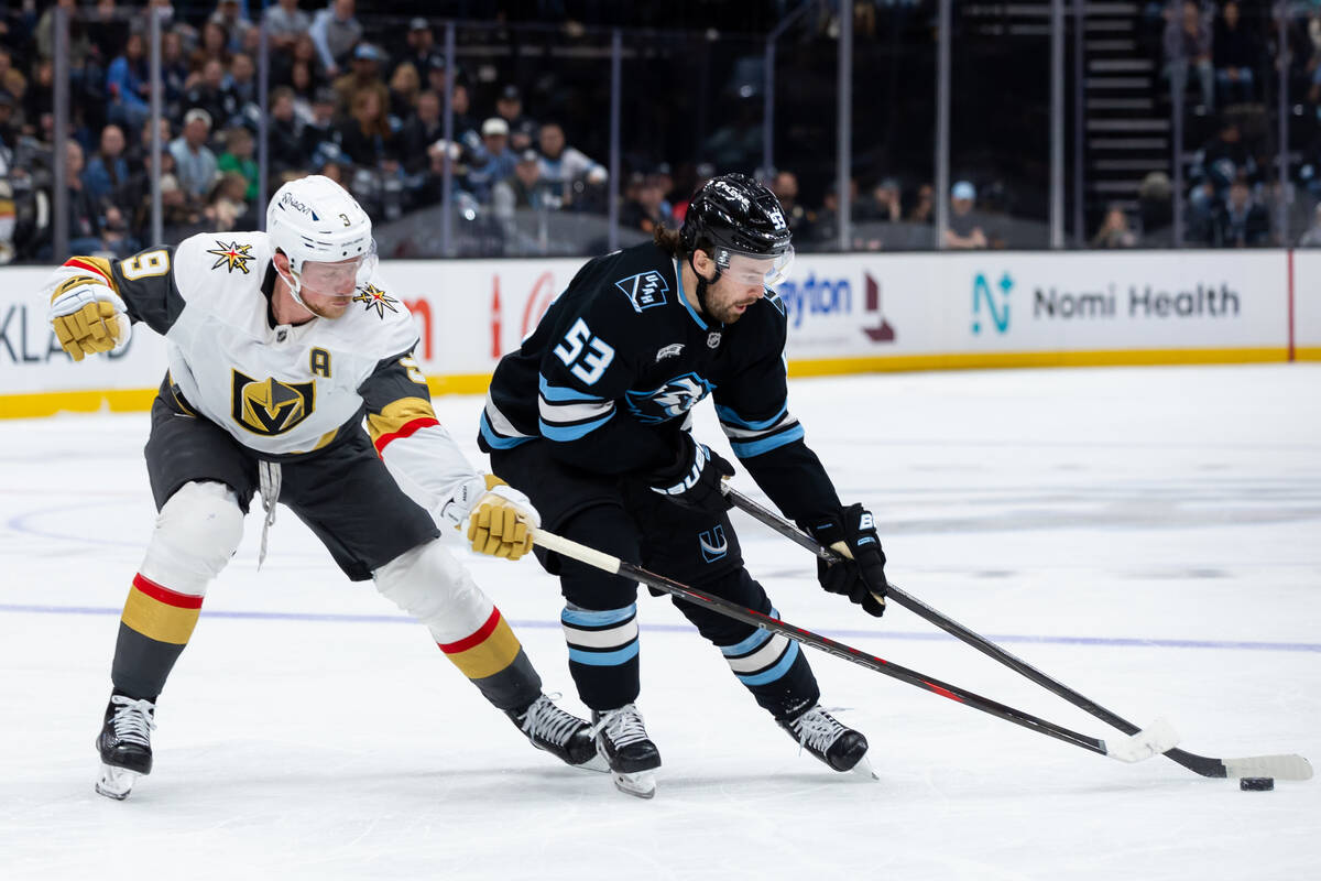 Vegas Golden Knights center Jack Eichel (9) tries to take the puck from Utah Mammoth left wing ...