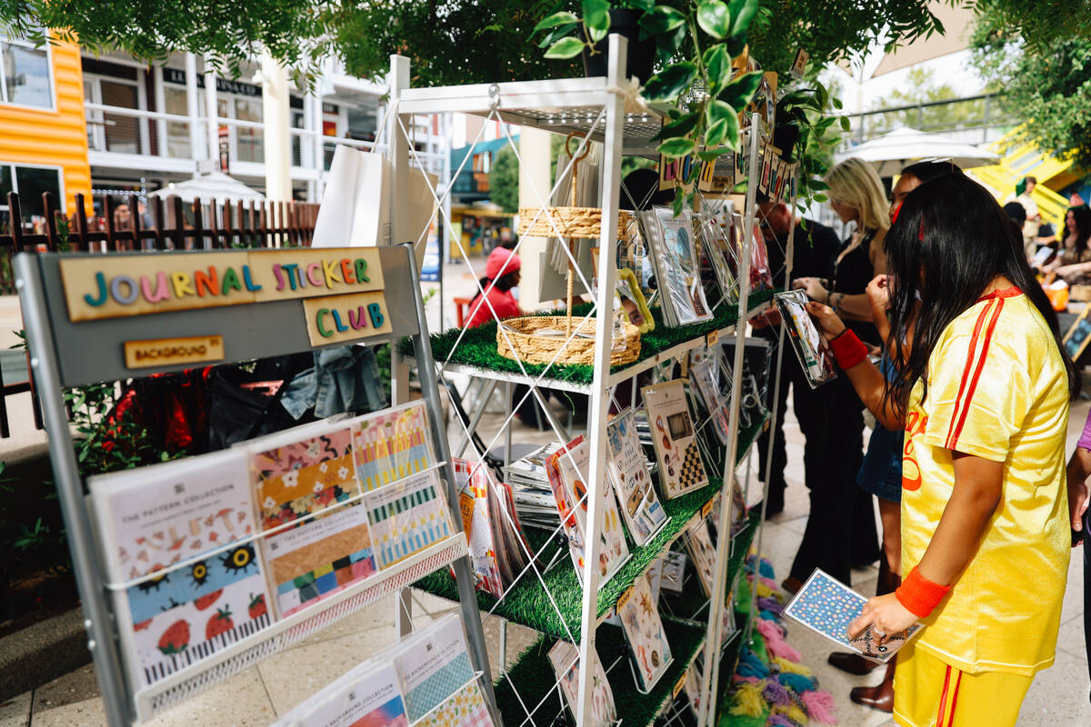 Crafters look through sets to use for journaling during a junk journaling meet-up at Shop Mama ...