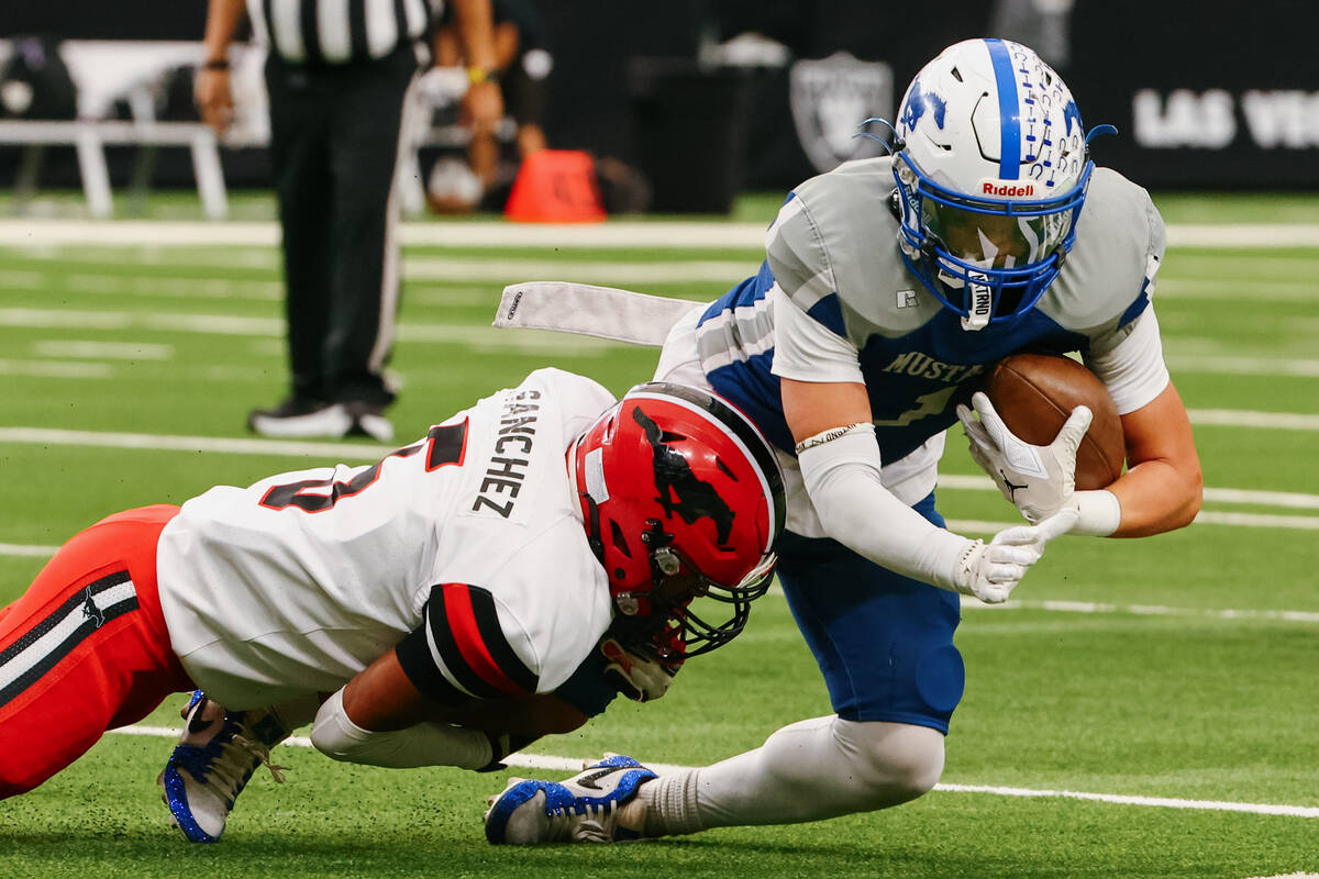 Pershing County defensive back Ramon Sanchez (5) tackles Needles wide receiver Robert Tapia (1) ...
