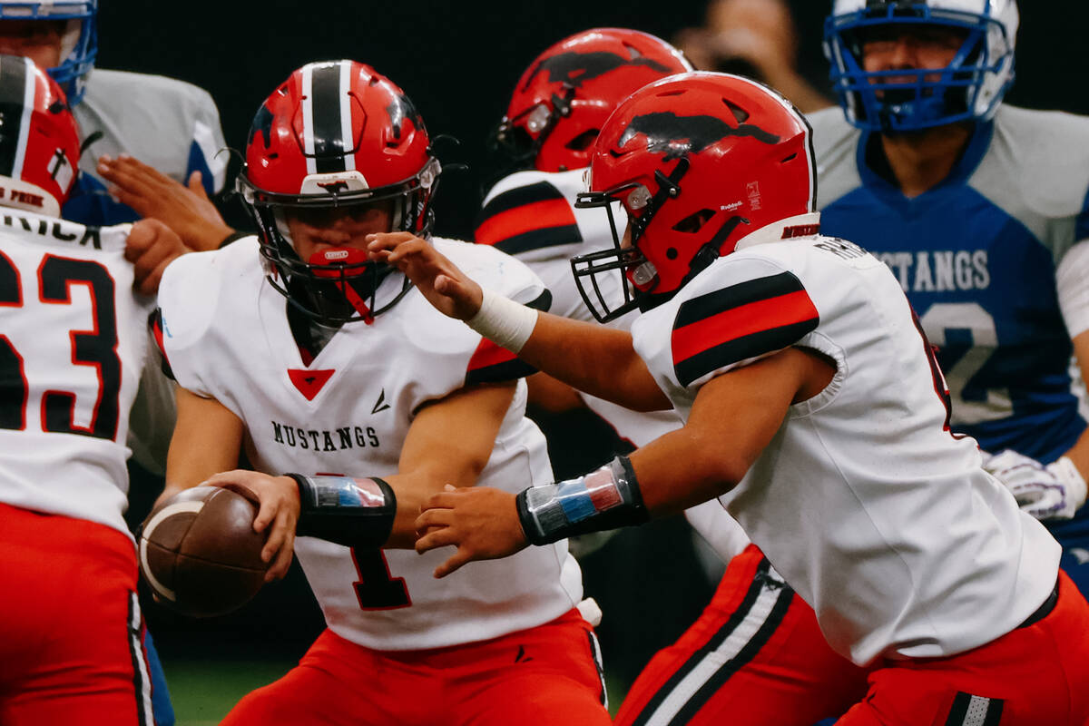 Pershing County quarterback Ayden Montes (1) hands the ball off during the second half of the 2 ...
