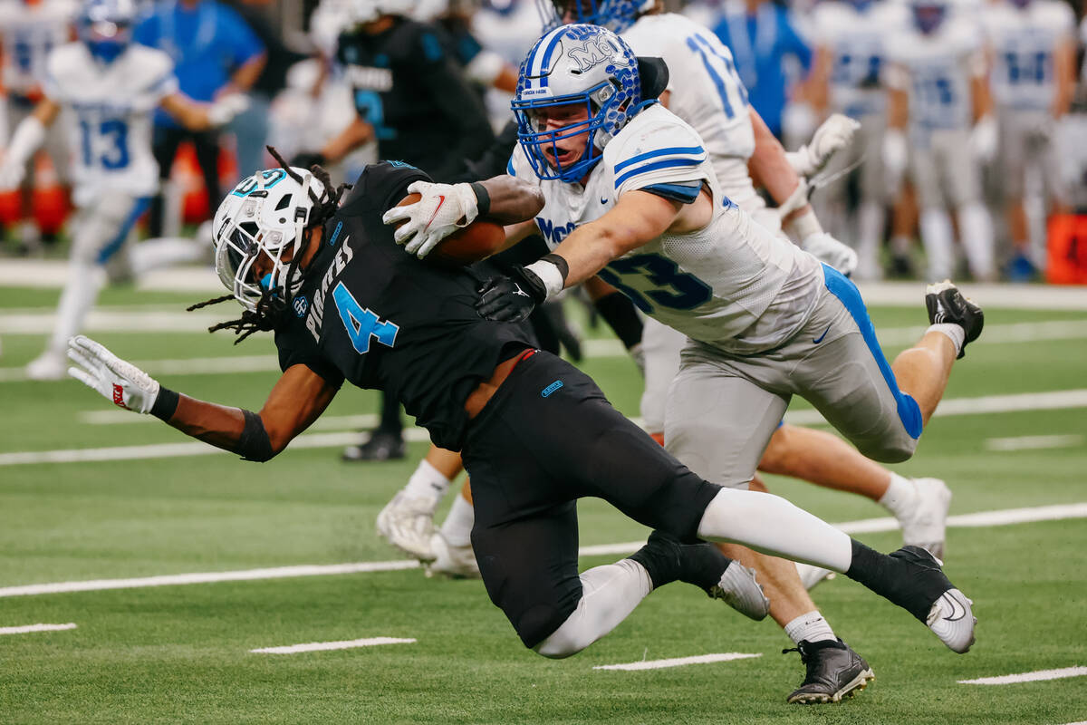 McQueen middle linebacker Zacary Draeger (33) tackles Sloan Canyon running back Jermaine Wilson ...