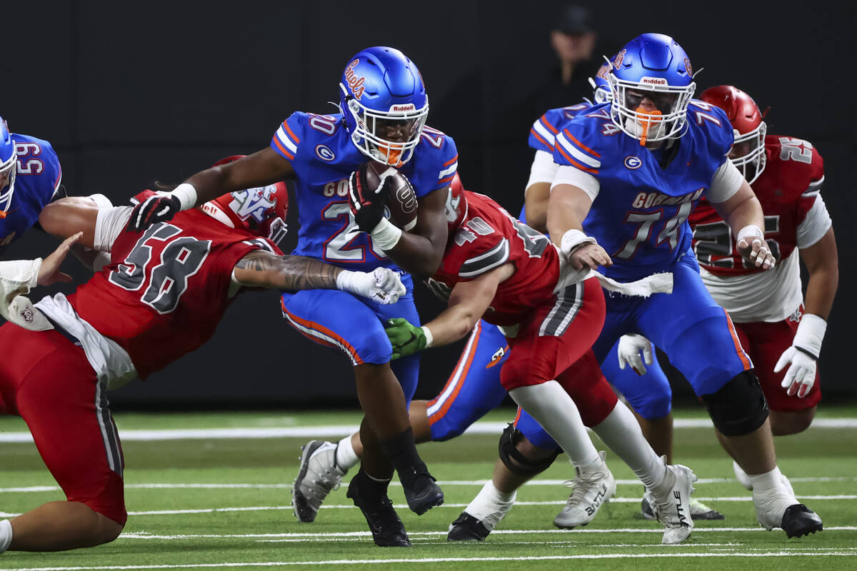 Bishop Gorman running back Noah Cole (20) runs the ball as Arbor View’s Tani Maafala-bar ...