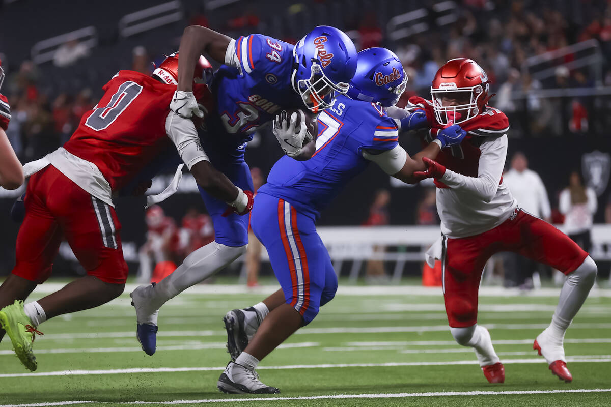 Bishop Gorman running back Braylen Rayford (34) gets tackled by Arbor View’s Kamareion B ...